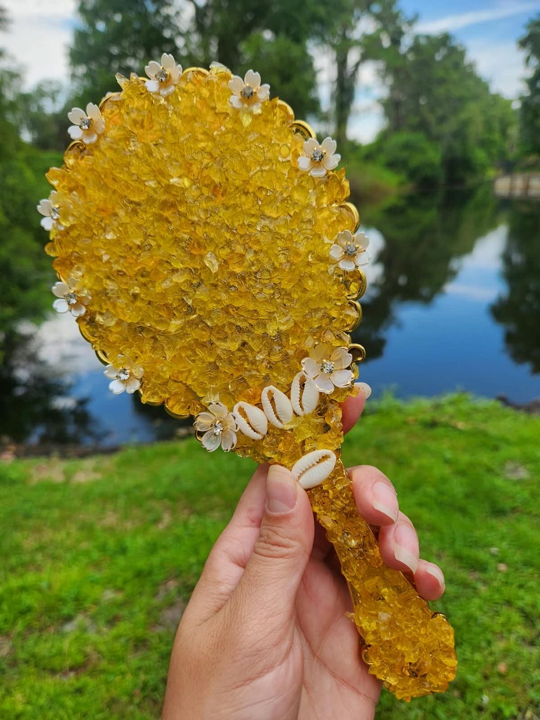 Verso do espelho Reflexo de Areia coberto de crushed glass dourado, com florzinhas brancas