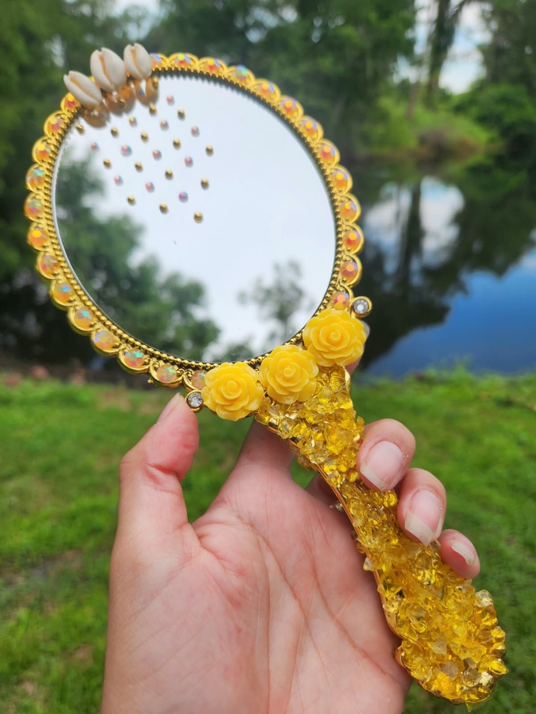 Espelho Reflexo de Areia com crushed glass dourado, rosas amarelas e búzios